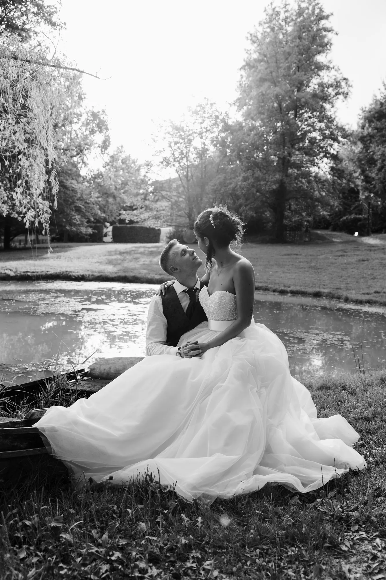 Un momento di tenerezza degli sposi accanto al laghetto, in bianco e nero — Luméa Wedding
